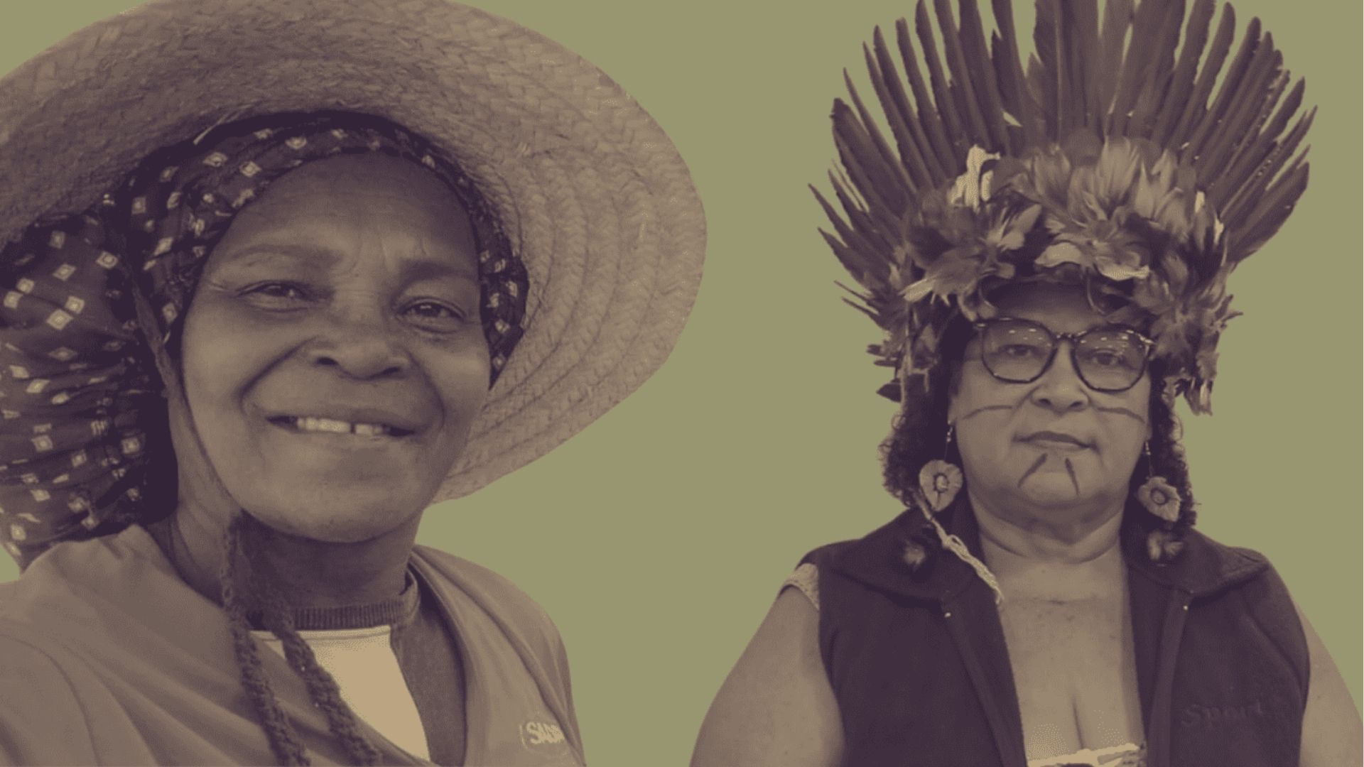 Duas mulheres fortes, uma com chapéu de palha e a outra com cocar de penas tradicionais, sorrindo e olhando para a câmera